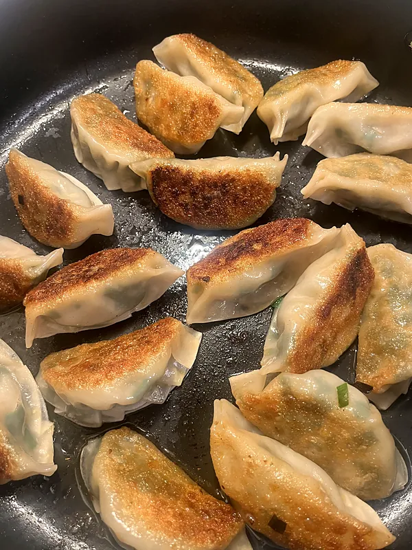 Golden pan-fried dumplings in a skillet